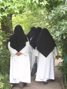 back view of nuns walking through garden